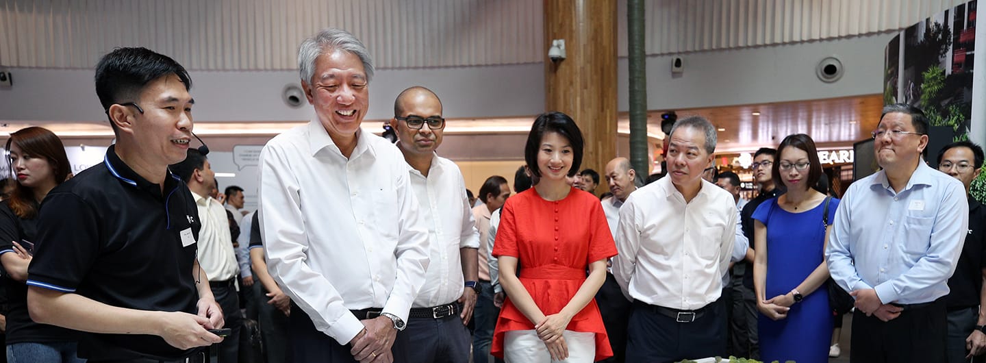 Group of people including government officials in an indoor setting, some in formal wear.